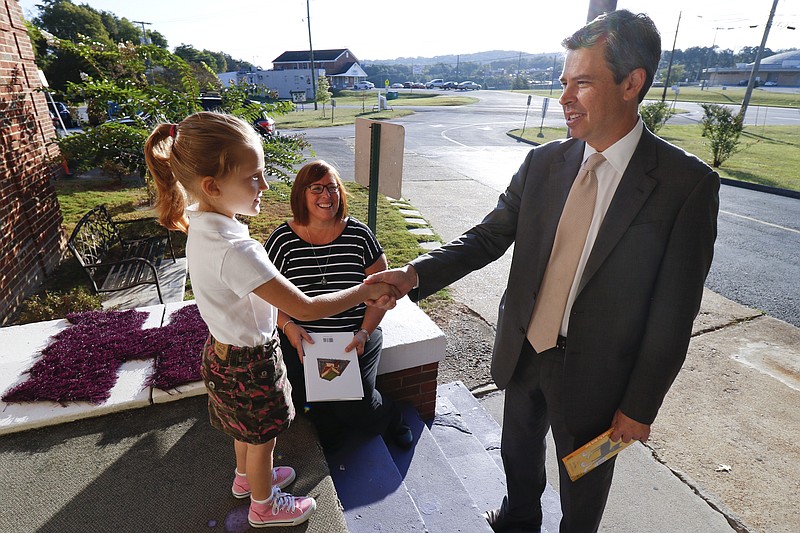 Staff Photo by Dan Henry / The Chattanooga Times Free Press- 9/22/15. Kindergartner Malleri Chambers, left, greets Chattanooga Mayor Andy Berke as he arrives at Harrison Elementary School to hand out library cards and read to kindergarteners on Tuesday, September 22, 2015. 