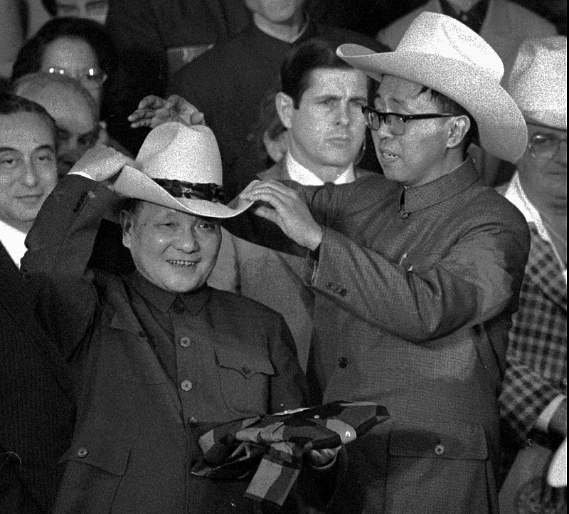
              FILE - In this Feb. 2, 1979 file photo, an aide helps Chinese former leader Deng Xiaoping try on a cowboy hat presented to him at a rodeo in Simonton, Texas. One wore a cowboy hat. Another visited Disneyland and Hollywood. Chinese President Xi Jinping’s trip to the U.S. this week is the latest in a string of visits made over the years by China’s leaders since formal diplomatic relations were established between Washington and Beijing in 1979. (AP Photo, File)
            