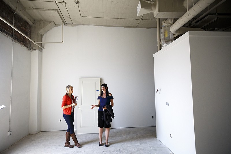 Director of operations Heather Everett, right, and receptionist Gabby Palmer stand in a 2-bedroom loft under development at the Clemons building Wednesday, Sept. 23, 2015, in Chattanooga, Tenn. The building, which dates back to the early 1920s, is being restored to offer luxury downtown loft apartments by owner and developer Vic Desai.