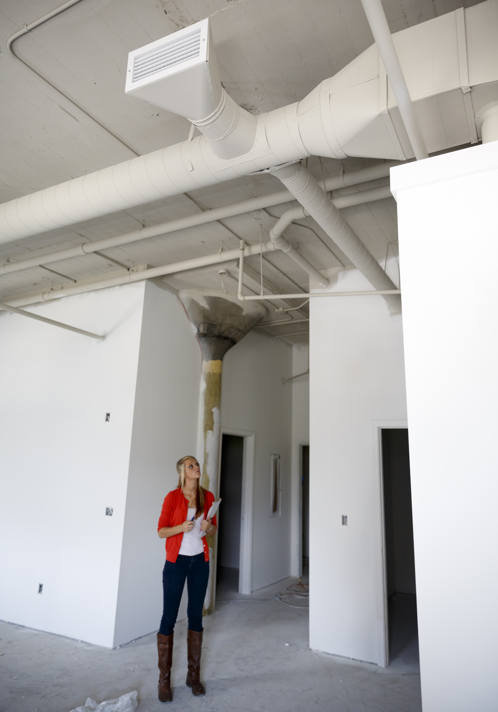 Gabby Palmer looks up at the open ceiling of a 2-bedroom loft apartment under development at the Clemons building Wednesday, Sept. 23, 2015, in Chattanooga, Tenn. The building, which dates back to the early 1920s, is being restored to offer luxury downtown loft apartments by owner and developer Vic Desai.