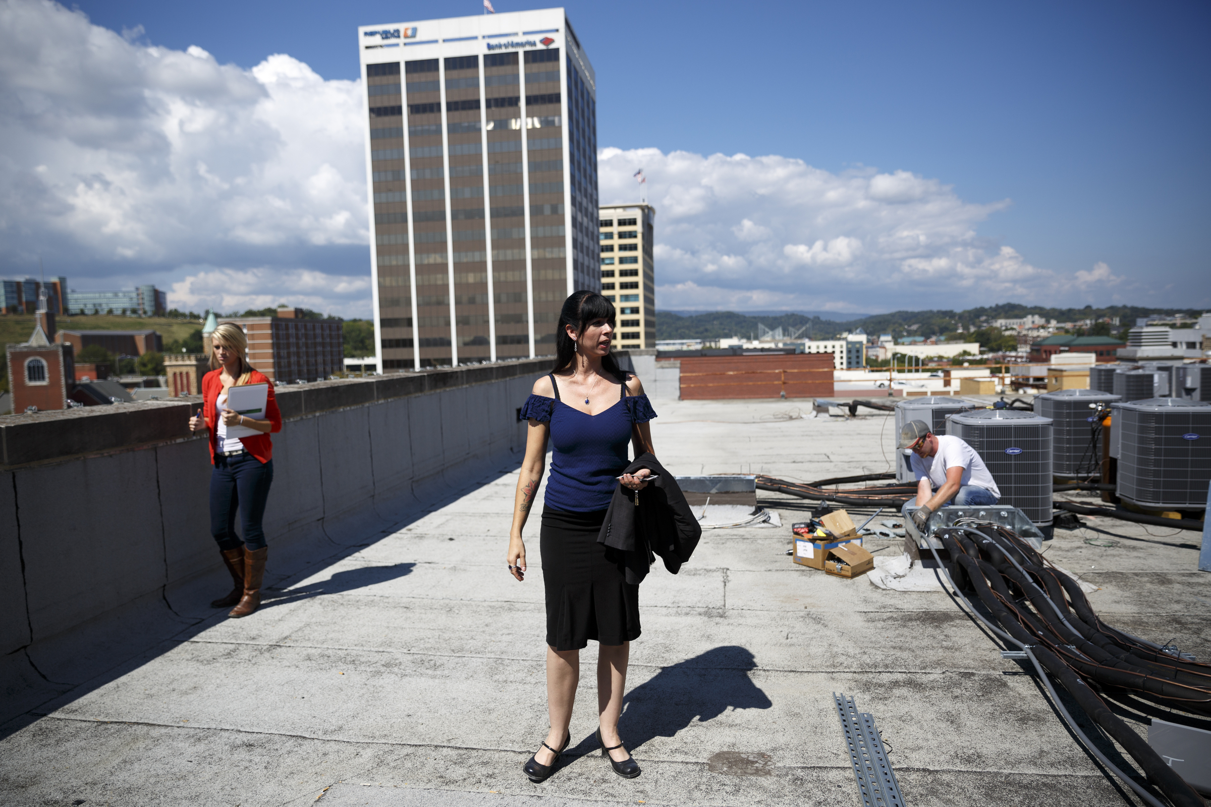 Director of operations Heather Everett, center, stands with Gabby Palmer, left, on the room of the Clemons building where a deck will be located, along with a nearby rooftop dog park, on Wednesday, Sept. 23, 2015, in Chattanooga, Tenn. The building, which dates back to the early 1920s, is being restored to offer luxury downtown loft apartments by owner and developer Vic Desai.