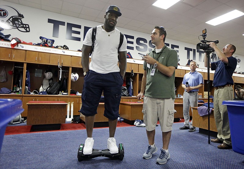 
              In this Wednesday, Sept. 23, 2015, photo, Tennessee Titans linebacker Brian Orakpo is interviewed in the locker room while riding on a motorized skateboard in Nashville, Tenn. Many of the Titans players use the devices to travel through the team's facility. (AP Photo/Mark Humphrey)
            