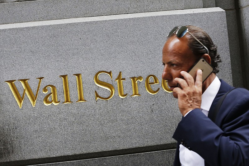 
              FILE - In this Monday, July 6, 2015 file photo, a man uses a mobile phone while walking by a building in the Financial District in New York.  Asian stocks took a hit from weak Chinese factory data Wednesday, Sept. 23, 2015,  while European stocks rose, with shares of Volkswagen stabilizing after its emissions rigging scandal triggered a dramatic slide. (AP Photo/Mark Lennihan, File)
            