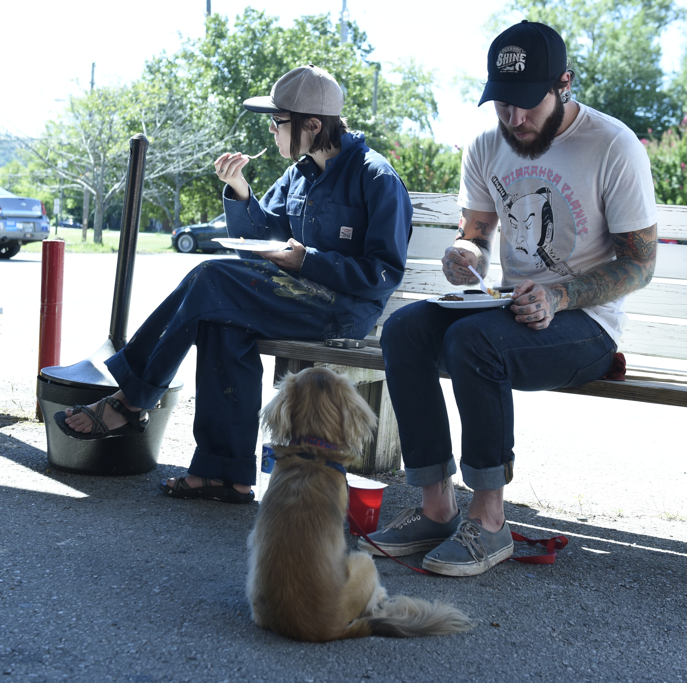 Ashley Hamilton, left, and Justin Butts eat lunch on a bench while Butts's dog Huey sits and waits after a worship service at the Mercy Junction Justice and Peace Center at St. Andrews in the Highland Park community on Sunday, Sept. 13, 2015, in Chattanooga, Tenn.