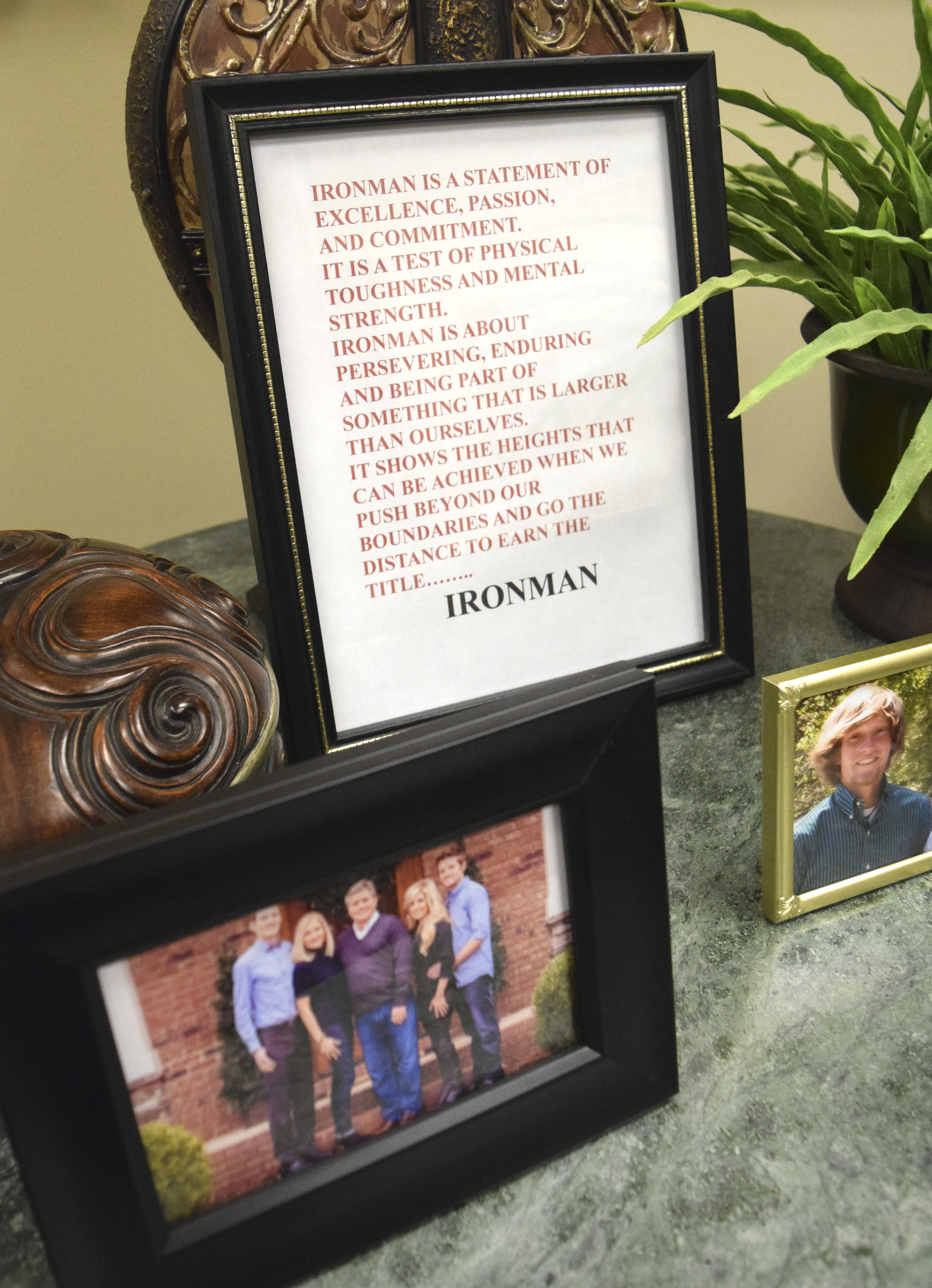 A framed testement to the Ironman is framed along with Bean Family photos at the family business on Hixson Pike.  The Bean family spoke to the Times Free Press about their 28-year old son, elite runner Cameron Bean, who was killed Monday after being hit by car while running.  Cameron was training his father, Steve, for this Sunday's Ironman.