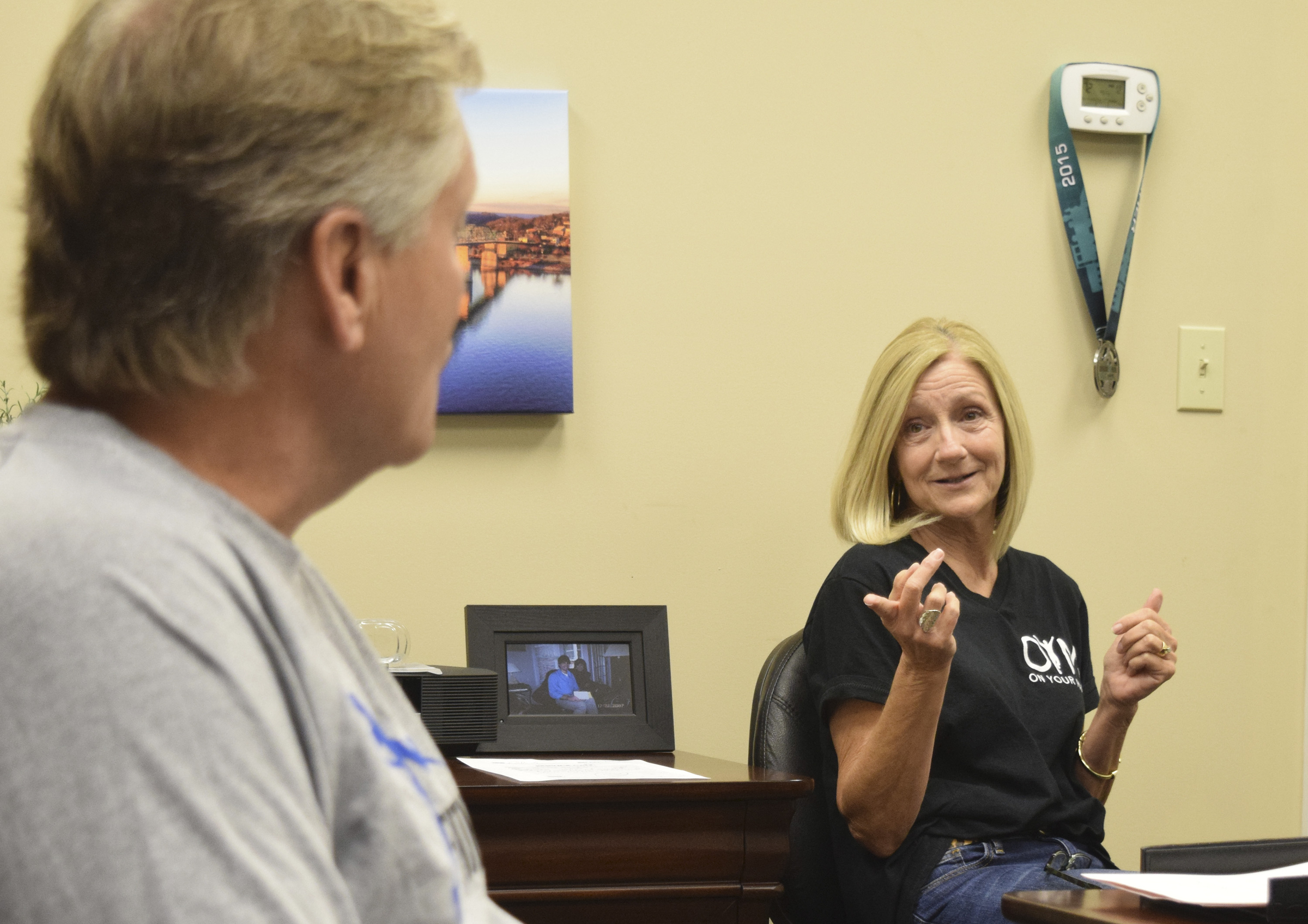Lisa Bean talks about her son, Cameron, while husband Steve listens in the foreground.  The Bean family spoke to the Times Free Press about their 28-year old son, elite runner Cameron Bean, who was killed Monday after being hit by car while running.  Cameron was training his father, Steve, for this Sunday's Ironman.