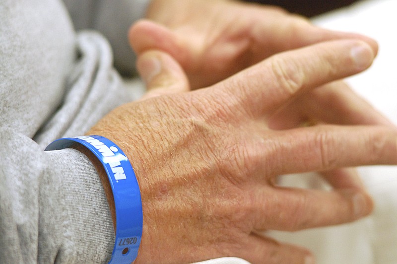 Steve Bean wears his Ironman bracelet while he listens to his wife, Lisa, share a story abound their son, Cameron. The Bean family spoke to the Times Free Press about their 28-year old son, elite runner Cameron Bean, who was killed Monday after being hit by car while running.  Cameron was training his father, Steve, for this Sunday's Ironman.  