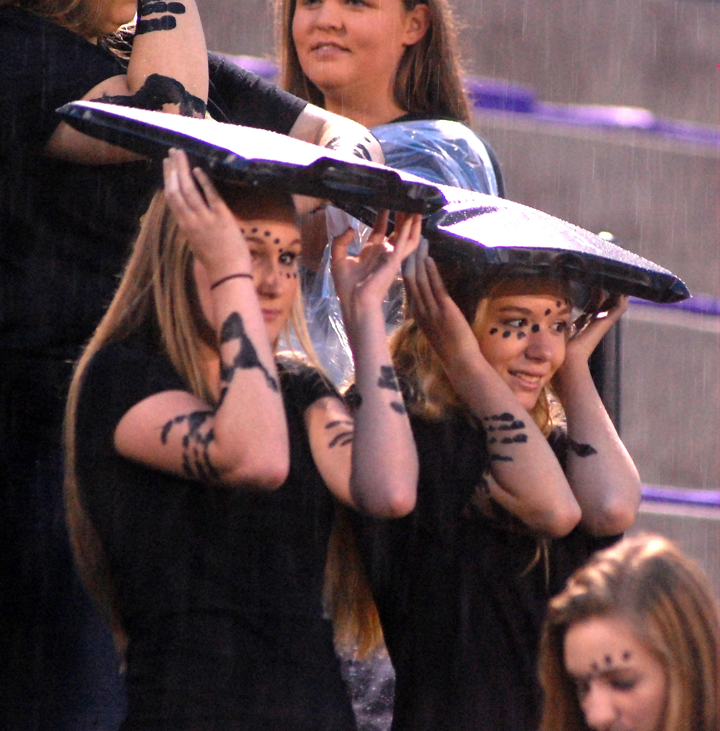 Fans in the Sequatchie County student section use seat cushions to shelter from the rain before the game. The Bledsoe County Warriors visited the Sequatchie County Indians in TSSAA football action Saturday September 25, 2015.
