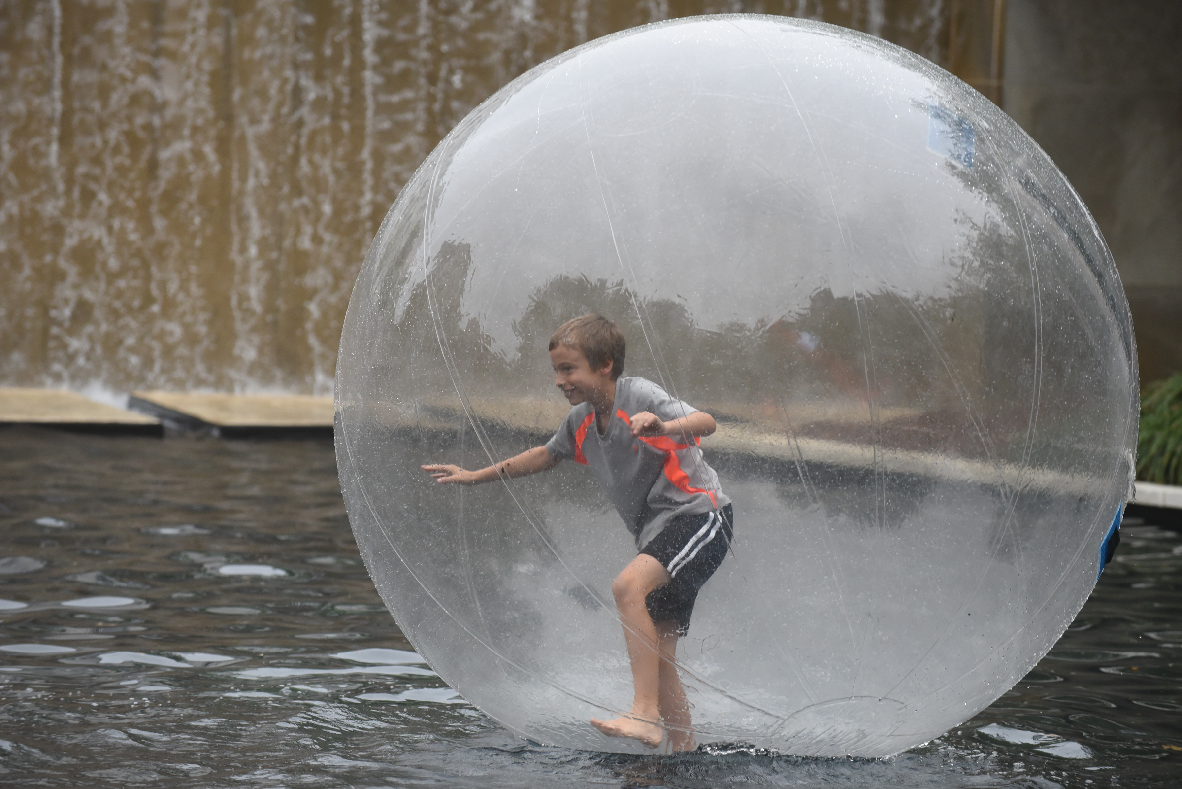 Jonah Biondolillo plays in an inflatable ball in the Miller Park pond during Chattanooga's 