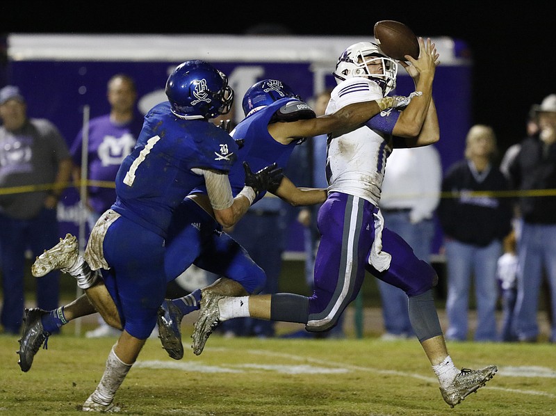 Staff Photo by Dan Henry / The Chattanooga Times Free Press- 9/25/15. Boyd-Buchanan's Kohl Henke (1) and Jeremy Borders (6) break up a pass intended for Marion County's (12) during the first half of play at the Buccaneers home field Friday, September 25, 2015.