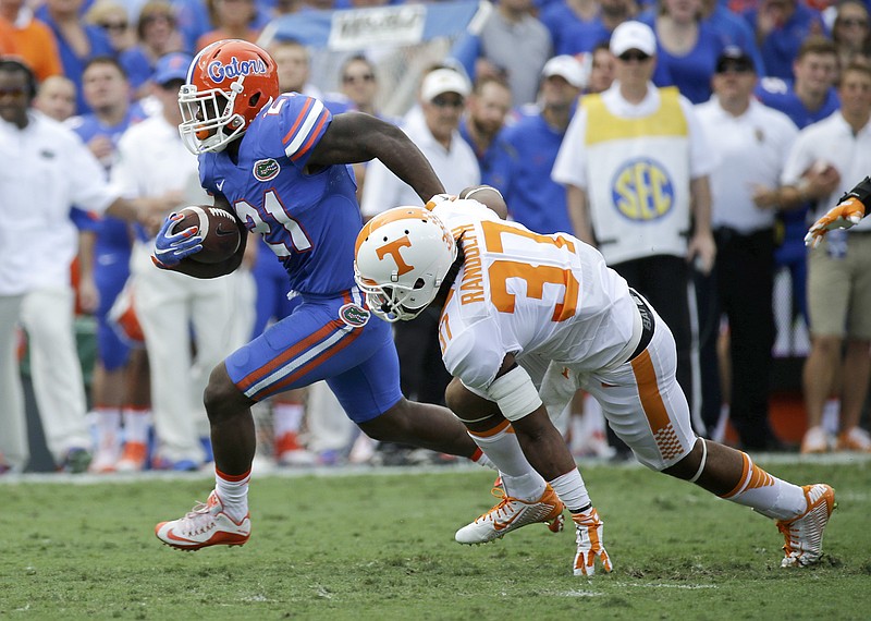 Florida running back Kelvin Taylor, left, runs for a 47-yard gain past Tennessee defensive back Brian Randolph (37) during the first half of an NCAA college football game, Saturday, Sept. 26, 2015, in Gainesville, Fla. (AP Photo/John Raoux)