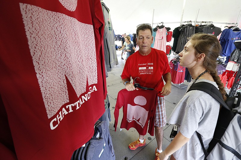Staff Photo by Dan Henry / The Chattanooga Times Free Press- 9/24/15. Rudy Chavez and his daughter Allie Chavez look through the Ironman store on Thursday, September 24, 2015.