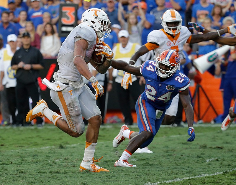 Tennessee running back Jalen Hurd, left, runs for a 10-yard touchdown past Florida defensive back Brian Poole (24) during the second half of an NCAA college football game, Saturday, Sept. 26, 2015, in Gainesville, Fla.