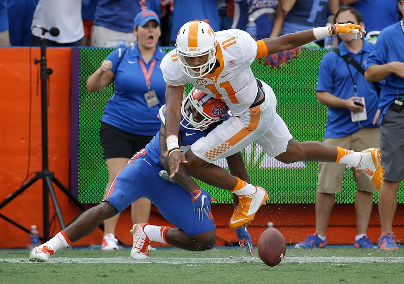 Tennessee quarterback Joshua Dobbs (11) fumbles the ball as he is tackled by Florida defensive back Keanu Neal, left, during the first half of an NCAA college football game, Saturday, Sept. 26, 2015, in Gainesville, Fla. The ball went out of bounds and Tennessee retained possession.