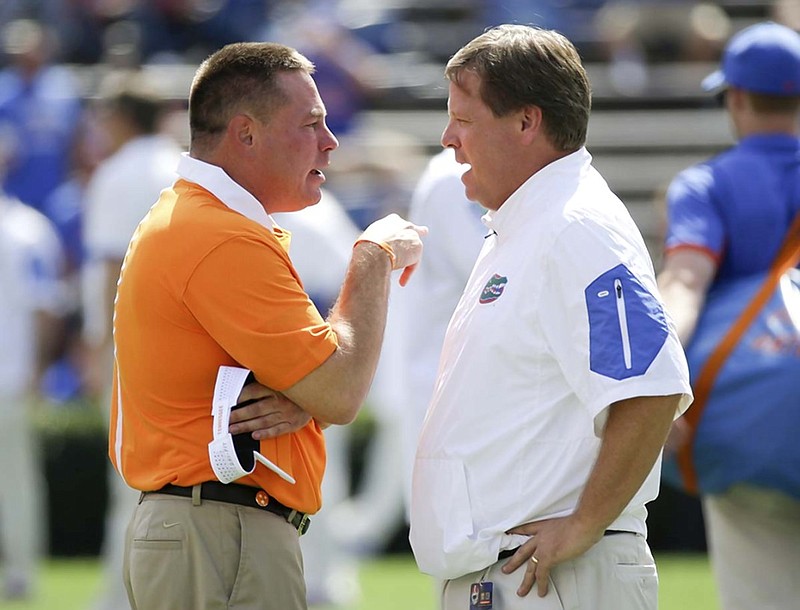 Tennessee coach Butch Jones, left, and Florida coach Jim McElwain meet at midfield before Saturday's Southeastern Conference matchup at "The Swamp" in Gainesville. The Gators rallied past the Volunteers for their 11th straight win in the series.