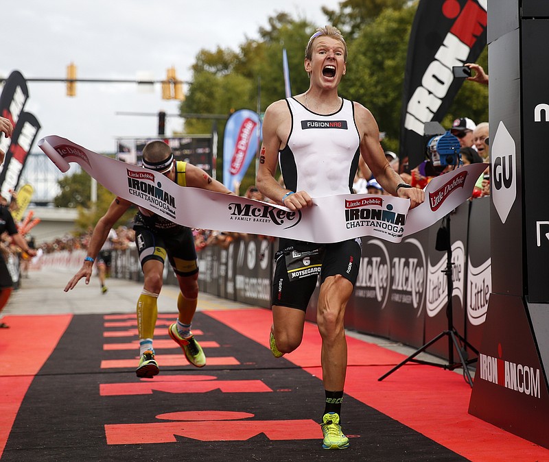 Kirill Kotsegarov, right, crosses the finish 2 seconds ahead of Matt Chrabot in the final meters to win the Ironman Triathlon in the closest Ironman finish in history on Sunday, Sept. 27, 2015, in Chattanooga, Tenn. This marks the second year the triathlon has been held in Chattanooga.