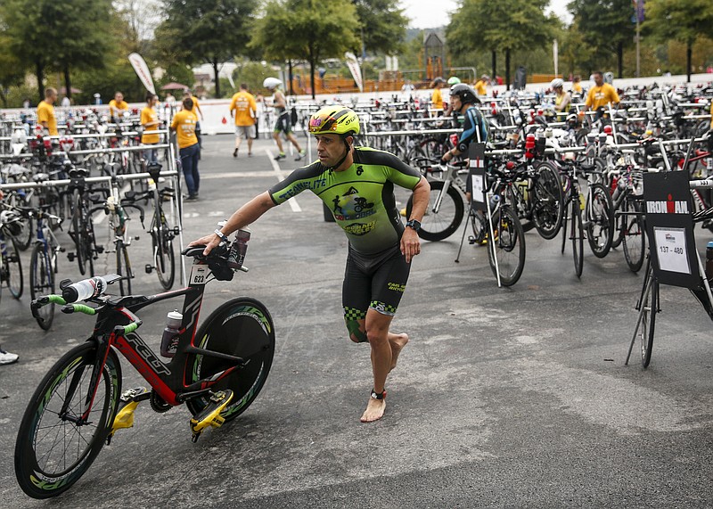 Richie Caiazza wheels his bike through the first transition during the 2015 Chattanooga Ironman.