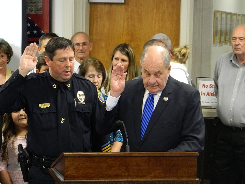 Mark Gibson, left, takes the oath of office for his new role as chief of the Cleveland Police Department, with Mayor Tom Rowland administering the ceremony. Gibson began his first day as chief on Sept. 21, selected from 36 candidates who applied for the position