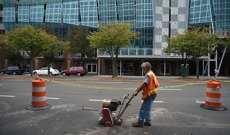 Daniel Smith, with Thomas Brothers, works Monday, Sept. 28, 2015, on the new bike lane that will be created on Broad Street.