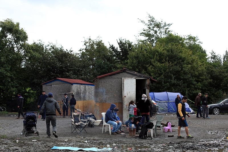 
              In this photo taken Friday, Sept. 18, 2015, migrants from Syria wait in the migrant camp of Grande Synthe, before an attempt to get to Britain, outside Dunkirk, northern France. Migrants in Teteghem or nearby Grande-Synthe wait eagerly for the service they signed up for. People smugglers who get rich off desperate migrants span the globe, and their tentacles extend into nooks and crannies like Teteghem, a small town outside Dunkirk. Here the smuggling kingpins are firmly in control, and growing nasty. (AP Photo/Thibault Camus)
            