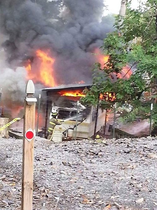 A camper at Swann's Marina in Dandridge burns Saturday morning. Preceded by an explosion, the fire left two adults and a child burned.