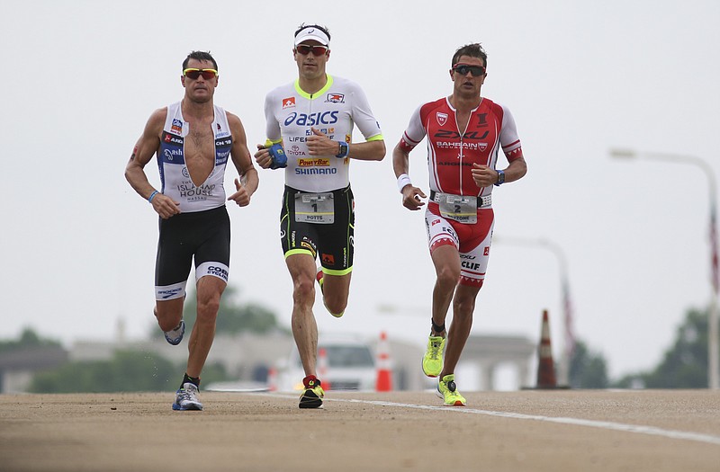 Staff Photo by Dan Henry / The Chattanooga Times Free Press- 5/17/15. Professional triathletes Leon Griffin #4, Andy Potts #1 and Bozzone Terenzo #2 crest the Veteran's Bridge while running the first lap of the run course during the inaugural Sunbelt Bakery Ironman 70.3 Chattanooga race on Sunday, May 17, 2015. U.S. athlete Andy Potts won the race with a final time of 3:49:43. 