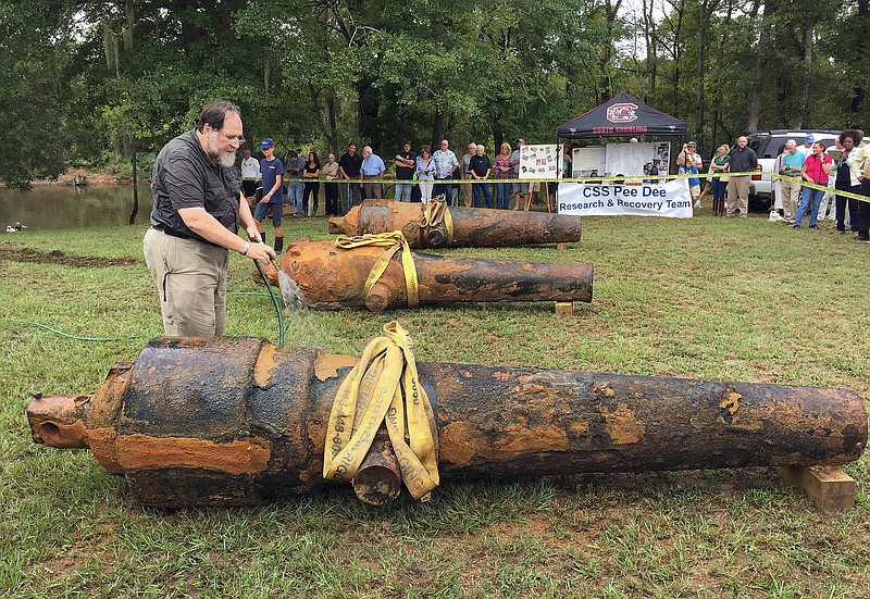 
              In this photo provided by the University of South Carolina, University of South Carolina archaeologist and state archaeologist Jon Leader washes and inspects one of the three Civil War cannons pulled from the Pee Dee River on Tuesday, Sept. 29, 2015, in Mars Bluff, S.C. The three cannons were dumped in the river by Confederate forces from the gunboat CSS Pee Dee in 1865 in order to keep them from falling into the hands of Union forces. (Margaret "Peggy" Ryan Binette/University of South Carolina via AP)
            