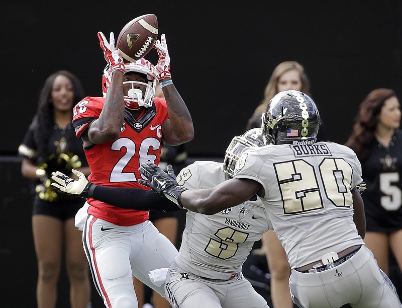 Georgia wide receiver Malcolm Mitchell (26) can't hold onto a pass as he is defended by Vanderbilt cornerback Taurean Ferguson (3) and safety Oren Burks (20) in the first half of an NCAA college football game Saturday, Sept. 12, 2015, in Nashville.