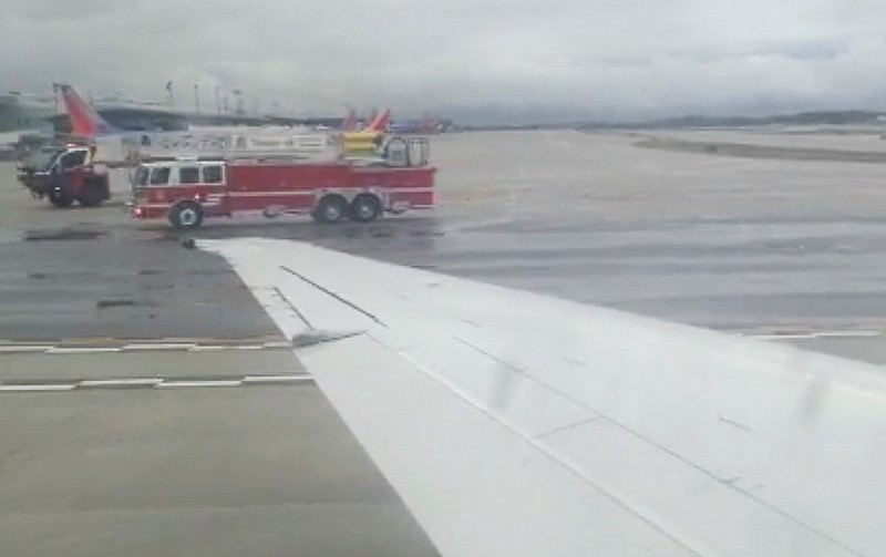 
              In this image made from video, the wing of Delta Flight 1086 is seen as fire trucks attend the aircraft, Wednesday, Sept. 30, 2015 at BWI Airport, near Baltimore. The flight made an emergency landing in Baltimore because of an engine problem. An Associated Press reporter on board the flight Wednesday, Brad Brooks, says the pilot provided few details on board other than saying there was an emergency. Brooks says the plane had been traveling from Atlanta to New York. (AP Photo/Brad Brooks)
            