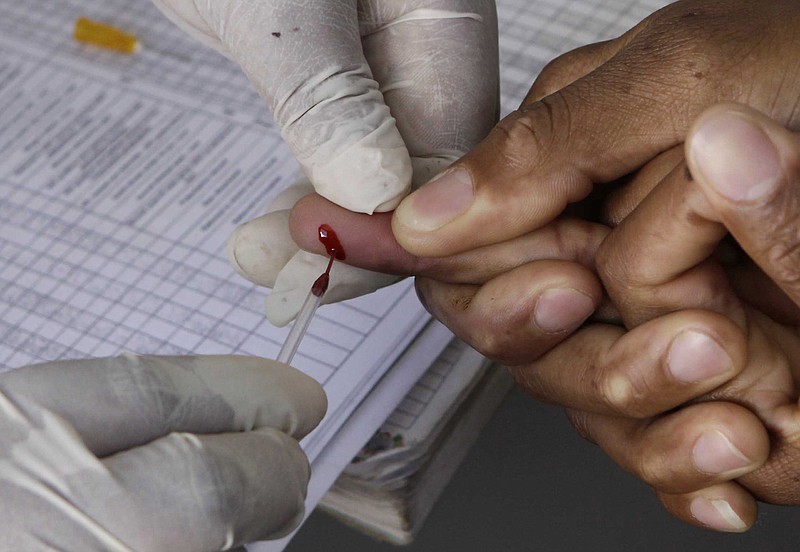 In this Monday Nov. 29, 2010, file photo a patient undergoes a pin prick blood test inside a mobile healthcare clinic parked in downtown Johannesburg. Passersby are encouraged to volunteer to be tested for the HIV virus in a "Know Your Status" government drive. The World Health Organization has revised its HIV guidelines to recommend that anyone who tests positive for the virus that causes AIDS should be treated immediately. The U.N. health agency had previously said doctors should wait to treat some people with HIV until their immune systems suggested they were getting sick. But in a statement Wednesday, Sept. 30, 2015,  WHO said the new recommendations are based on recent trials that have found early treatment "keeps people with HIV alive, healthier and reduces the risk of transmitting the virus." (AP Photo/Denis Farrell, File)
            