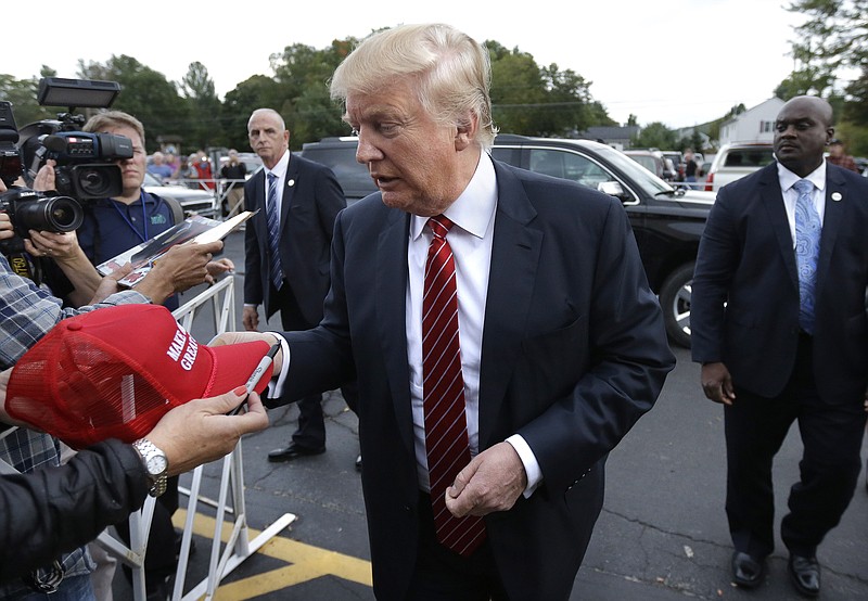 Republican presidential candidate, businessman Donald Trump signs autographs as he arrives at a campaign stop, Wednesday, Sept. 30, 2015, in Keene, N.H.