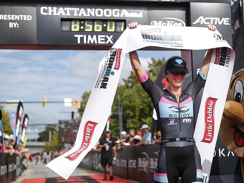 Carrie Lester holds up a banner after crossing the finish line to win the Ironman Triathlon on Sunday, Sept. 27, in Chattanooga, the second year the triathlon has been held here.
