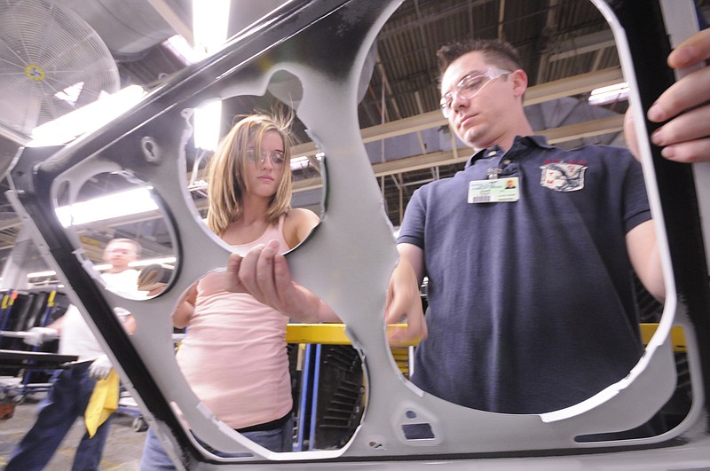 Josh Pellom, right, holds a range top as Katlan Bullard applies padding for a glass cover inside the plant at Roper Corporation in LaFayette. The appliance manufacturer  has taken aggressive steps to promote wellness by creating an onsite medical and wellness center for their employees and families.