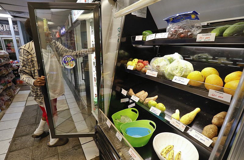 Gwenda Murphy looks for a soda in the case next to a small produce section at the Southside Market — Health in a Hurry Corner Store near Alton Park on Tuesday.