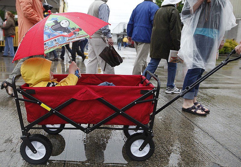 Aaden Baker holds an umbrella over his head as he rides in a wagon with his family at the National Cornbread Festival Saturday in South Pittsburg, Tenn in this file photo.  Rain could hinder the first, big weekend of fall festivals in the Chattanooga Area.