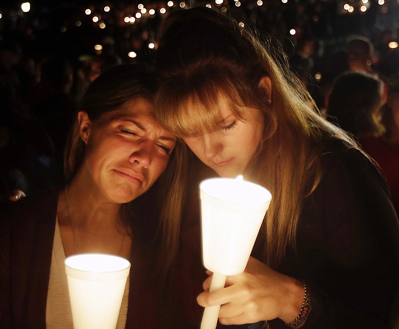 Kristen Sterner, left, and Carrissa Welding, both students at Umpqua Community College, embrace each other during a candlelight vigil for those killed during a shooting at the college Thursday, Oct. 1, 2015, in Roseburg, Ore.