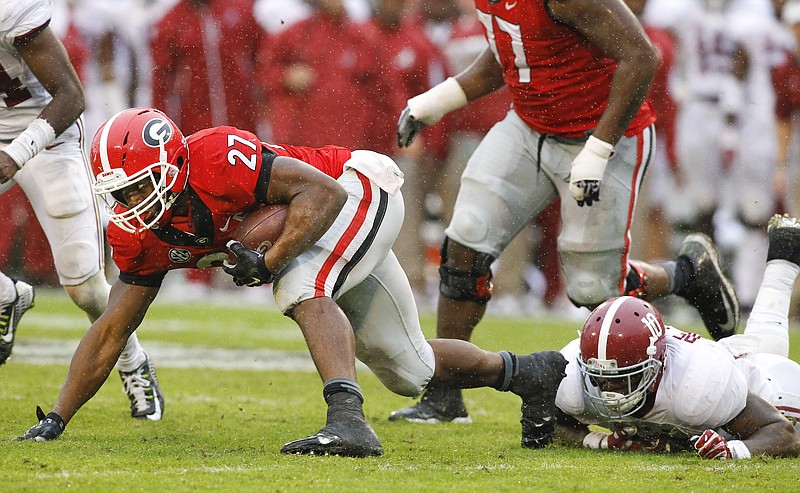 Georgia running back Nick Chubb (27) struggles for extra yardage here against Alabama, but he did provide the Bulldogs' main bright spot with an 83-yard touchdown run that gave him 100 yards for a 13th game in a row.