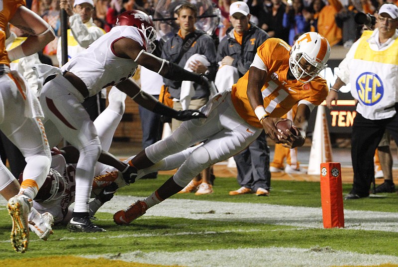 Staff Photo by Dan Henry / The Chattanooga Times Free Press- 10/3/15. UT quarterback Joshua Dobbs (11) dives past Arkansas defender DJ Dean (2) to score a touchdown during the first quarter of play on October 3, 2015. The Volunteers played the Razorbacks at home in Neyland Stadium late Saturday evening. 