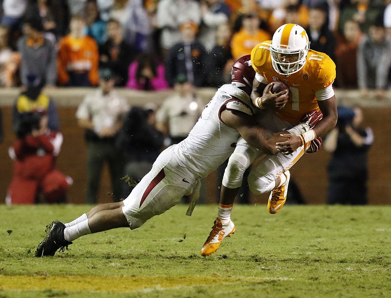 Staff Photo by Dan Henry / The Chattanooga Times Free Press- 10/3/15. UT quarterback Joshua Dobbs (11) gets sacked by Arkansas's Tevin Beanum (97) during the fourth quarter of play on October 3, 2015. The Volunteers lost to the Razorbacks 20-24 at home in Neyland Stadium late Saturday evening. 