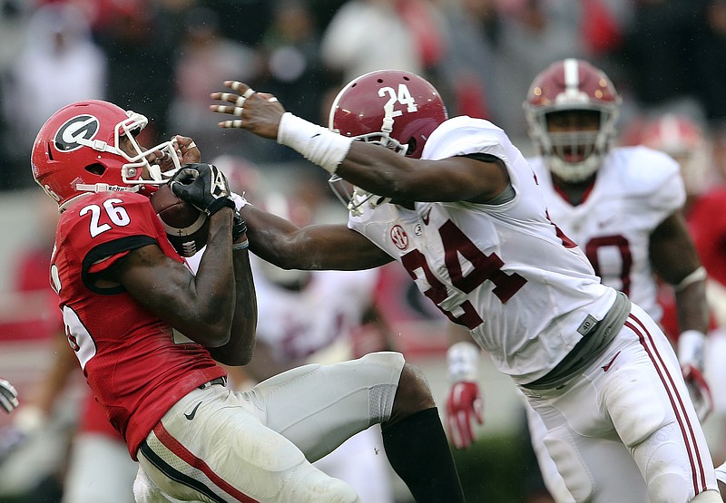 Receiver Malcolm Mitchell makes a catch for a first down and is tackled by  Geno Matias-Smith in the first quarter of the University of Georgia's game  against the University of Alabama, Saturday