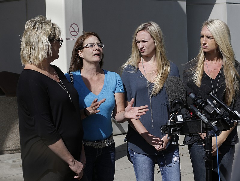 Bonnie Schaan, second from left, discuss her daughter, Cheyanne Fitzgerald, who was wounded in the shooting at Umpqua Community College, during a news conference outside Mercy Medical Center, Saturday, Oct. 3, 2015, in Roseburg, Ore. Cheyanne Fitzgerald, 16, is listed in critical condition from a gunshot wound that required the removal of her kidney. Fitzgerald was one of several people wounded when Chris Harper-Mercer walked into a class at the community college, Thursday and began shooting. Also seen are Cheyanne's aunt, Colleen Fitzgerald, left, and cousins, Kylie, third from left, and Courtney Fitzgerald.