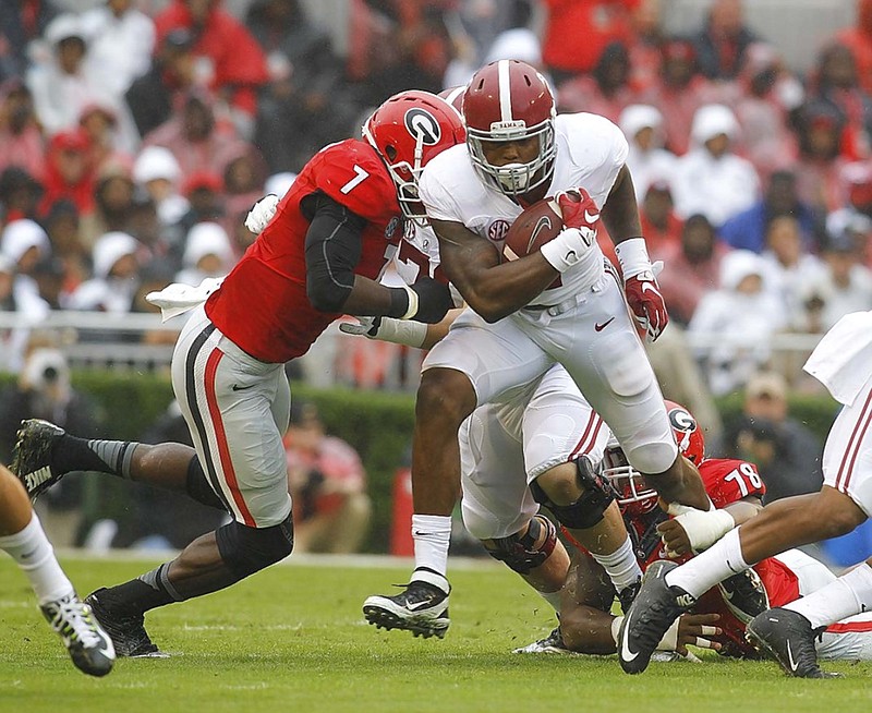 Alabama running back Derrick Henry tries to shake off Georgia linebacker Lorenzo Carter, left, and defensive tackle Trenton Thompson during the first half of Saturday's game in Athens, Ga. Henry rushed for a career-best 148 yards to help lead the Crimson Tide to a 38-10 win.