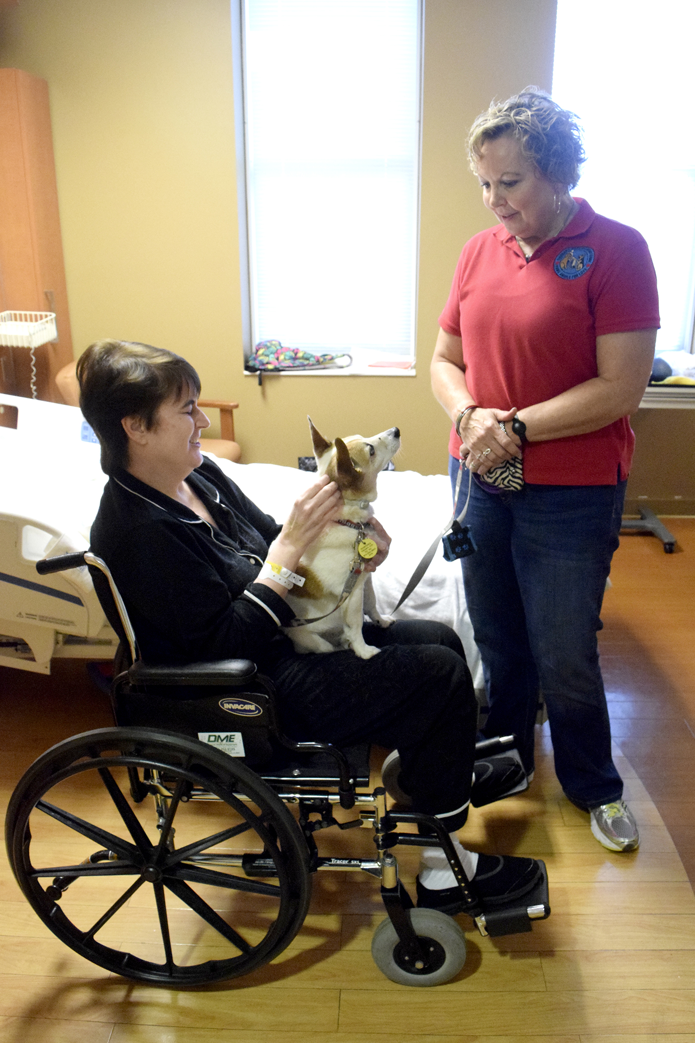 Erlanger Hospital patient, Edie Robinson, holds Georgia, a 12-year old Jack Russell Terrier while owner Susan Millican looks on. Erlanger Hospital is taking applications from dog owners for their pet to be a therapy dog.