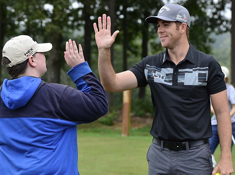 Former Baylor School golf standout Luke List high-fives Devyn Sizemore after giving the youngster tips to help improve his swing before the L2 Foundation charity tournament at WindStone Golf Club in Ringgold last year.