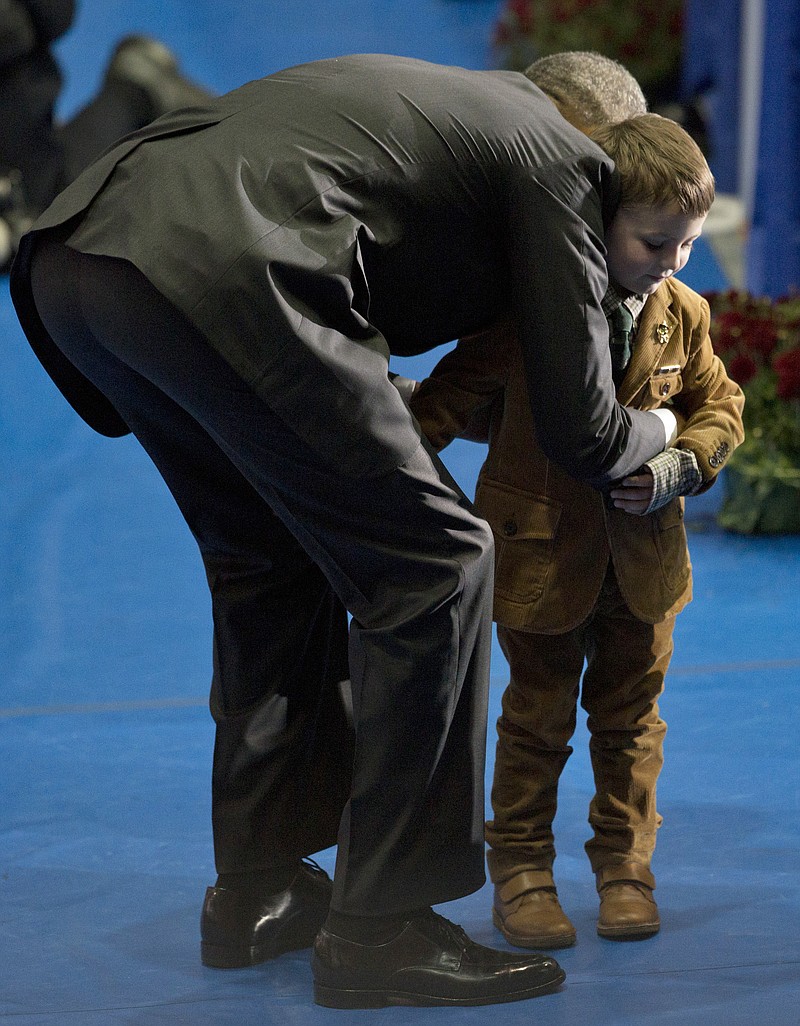 
              President Barack Obama embraces a small boy as he greets family members and coworkers of fallen firefighters during the National Fallen Firefighters Memorial Service at Mount St. Mary’s University’s Knott Athletic Recreation Convocation Complex (ARCC) in Emmitsburg, Md., Sunday, Oct. 4, 2015, to honor 84 firefighters who died in the line of duty in 2014 and three firefighters who died in previous years. (AP Photo/Carolyn Kaster)
            