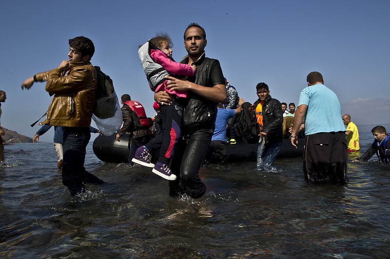 
              A Syrian refugee man carrying his daughter rushes to the beach as he arrives on a dinghy from the Turkish coast to the northeastern Greek island of Lesbos, Sunday, Oct. 4 , 2015. The U.N. refugee agency is reporting a “noticeable drop” this week in arrivals of refugees by sea into Greece - as the total figure for the year nears the 400,000 mark. Overall, the UNHCR estimates 396,500 people have entered Greece via the Mediterranean this year with seventy percent of them are from war-torn Syria. (AP Photo/Muhammed Muheisen)
            