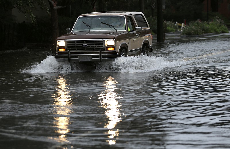 
              A motorist drives his truck through a flooded street in Charleston, S.C., Sunday, Oct. 4, 2015. President Barack Obama declared a state of emergency in South Carolina and ordered federal aid to bolster state and local efforts as flood warnings remained in effect for many parts of the East Coast through Sunday. (AP Photo/Chuck Burton)
            