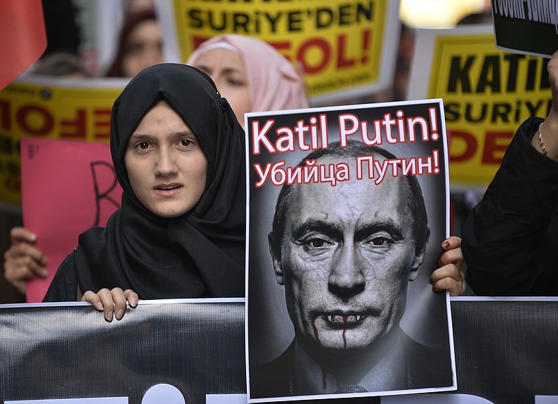 
              A demonstrator holds a picture depicting Russian President Vladimir Putin during a protest against Russian military operations in Syria, in Istanbul, Turkey, Saturday, Oct. 3, 2015. The picture reads both in Turkish and Russian: 'Murderer Putin'. In ramping up its military involvement in Syria's civil war, Russia appears to be betting that the West, horrified by Islamic State's atrocities, may be willing to tolerate Syrian President Bashar Assad for a while, perhaps as part of a transition. (AP Photo)
            