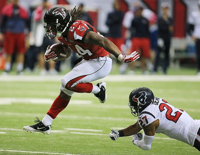 Falcons running back Devonta Freeman breaks a tackle attempt by Texans safety Quintin Demps on his way to the end zone for his second touchdown of the day during the second quarter of their NFL football game in Atlanta on Sunday, Oct. 4, 2015. 