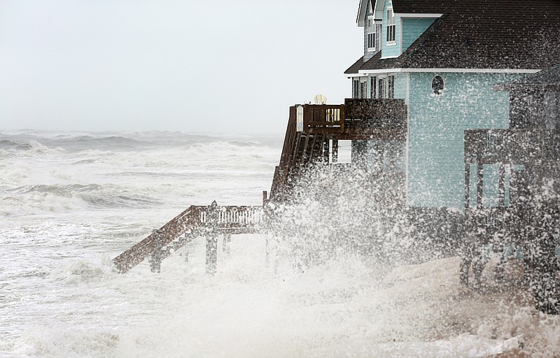 
              Waves batter the shoreline in Buxton on North Carolina's Hatteras Island during high tide on Sunday, Oct. 4, 2015. The Eastern Seaboard appeared to dodge the full fury of Hurricane Joaquin, which is veering out to sea. (Steve Earley/The Virginian-Pilot via AP)
            